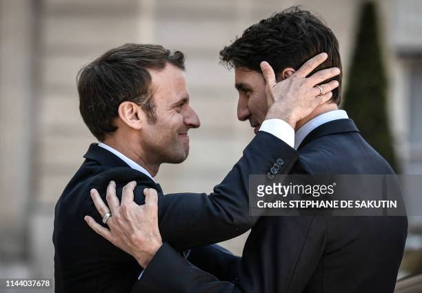 French President Emmanuel Macron bids farewell to Canadian Prime Minister Justin Trudeau as he leaves the Elysee presidential Palace following their...