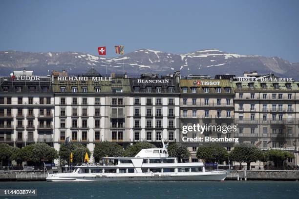 Ferry docks for passengers in front of buildings featuring signage for Montres Tudor SA, Richard Mille, Blancpain SA, Tissot SA and the Hotel De La...