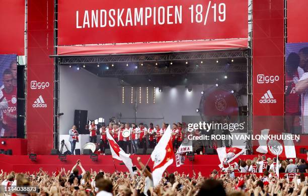 Ajax's players celebrate their 34th national champion title after winnning the 2019 Dutch Eredivisie championship outside the Museumplein in...