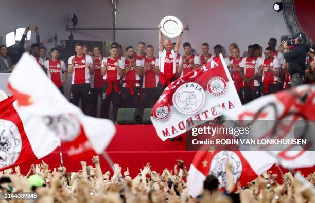 Ajax Amsterdam players celebrate with their fans as they celebrate their club's 34th national champion title after winnning the 2019 Dutch Eredivisie...