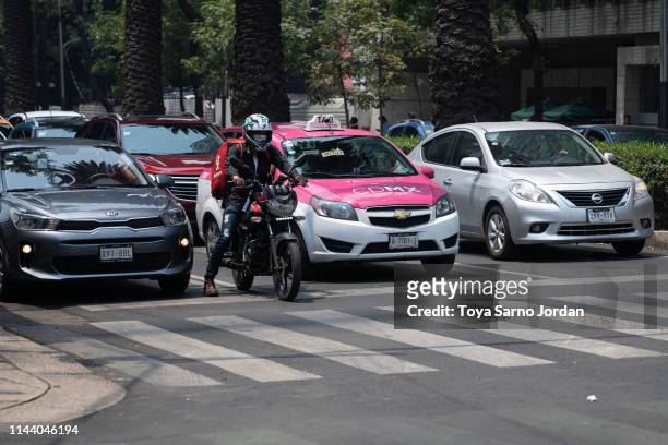 Man wears a face mask while riding his motorcycle on May 16, 2019 in Mexico City, Mexico. Mexico City's air pollution has been worsened as a...