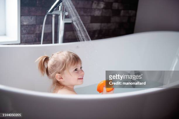 可愛的小女孩在浴缸裡玩 - infant with water 個照片及圖片檔