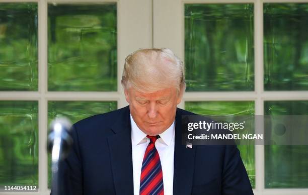 President Donald Trump looks down as he announces a new immigration proposal, in the Rose Garden of the White House in Washington, DC on May 16,...