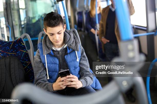 teenager playing a mobile game - play bus stock pictures, royalty-free photos & images