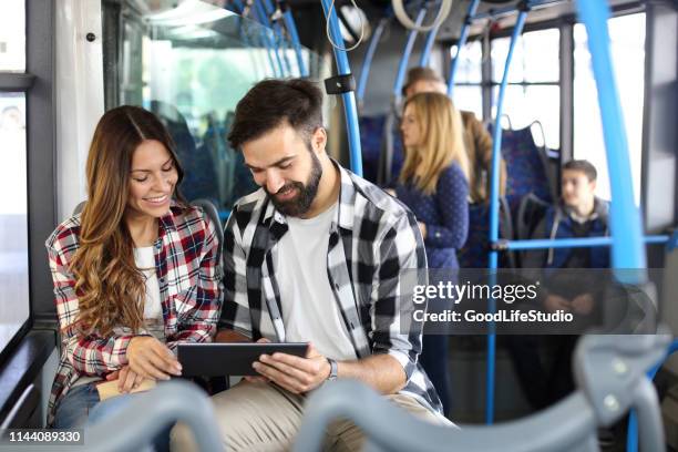pareja usando una tableta en un autobús - bus interior fotografías e imágenes de stock