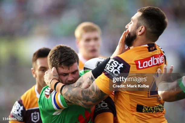 John Bateman of the Raiders fends off Jack Bird of the Broncos during the round 6 NRL match between the Canberra Raiders and the Brisbane Broncos at...