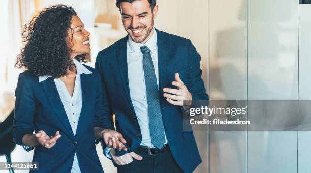 fröhliche geschäftsleuten zusammen spazieren - meeting candid office suit stock-fotos und bilder