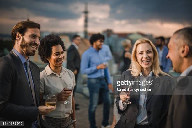 cheerful business colleagues communicating at the outdoor party. - business party stock pictures, royalty-free photos & images