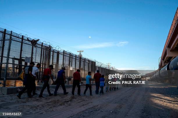 Migrants, mostly from Central America, queue to board a van which will take them to a processing center, on May 16 in El Paso, Texas. - About 1,100...