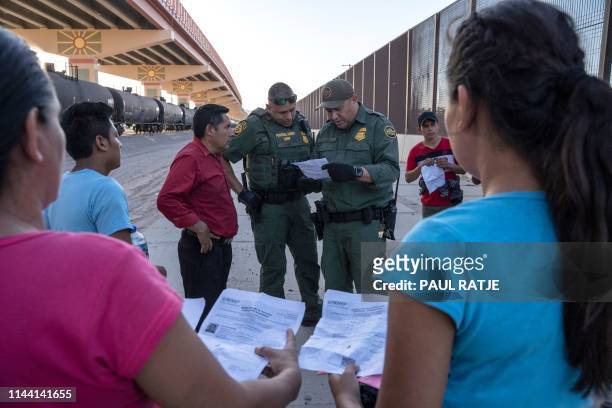 Customs and Border Protection agents check documents of a small group of migrants, who crossed the Rio Grande from Juarez, Mexico, on May 16 in El...