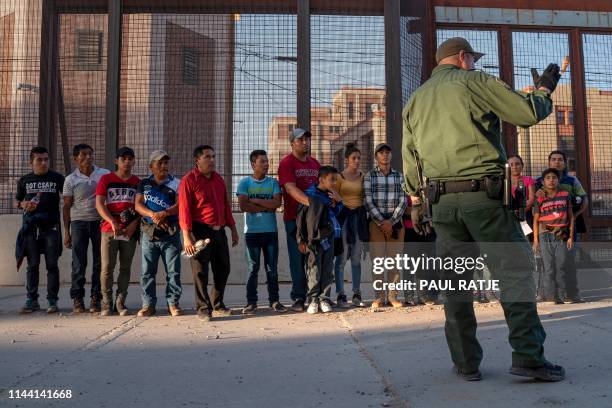 Migrants, mostly from Central America, que to board a van which will take them to a processing center, on May 16 in El Paso, Texas. - About 1,100...
