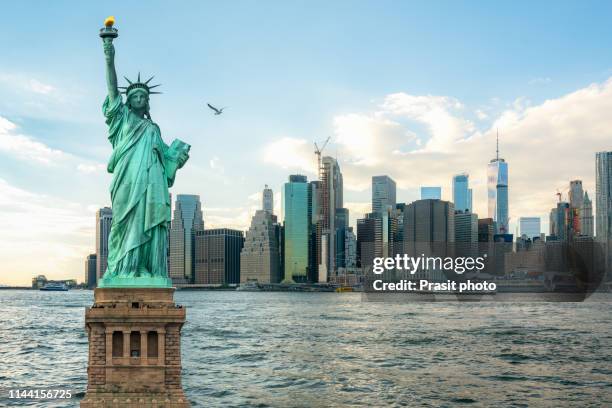 the statue of liberty with manhattan in new york city, usa - new york freiheitsstatue stock-fotos und bilder