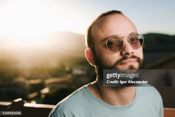 stylish man on a sunny afternoon on the terrace - tinted sunglasses stock pictures, royalty-free photos & images