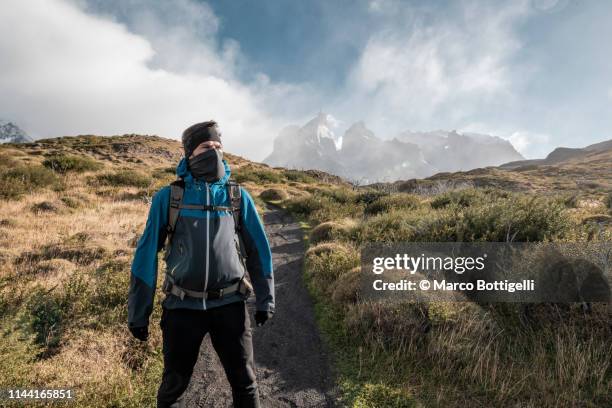 a determinated man looking away in torres del paine, chile - skimaske stock-fotos und bilder