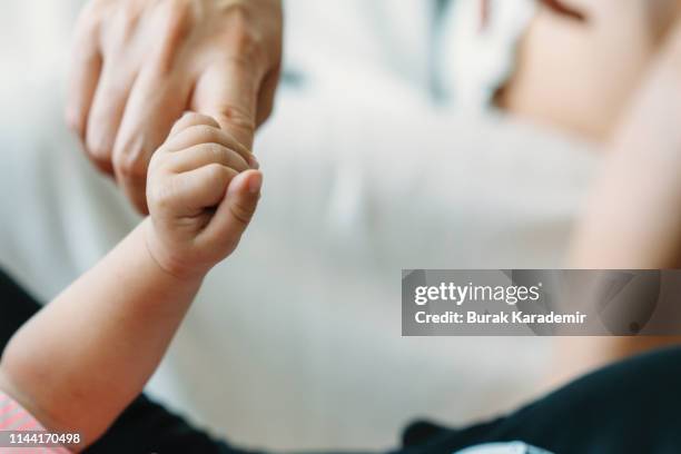 baby holding fathers hand - midwife stock pictures, royalty-free photos & images