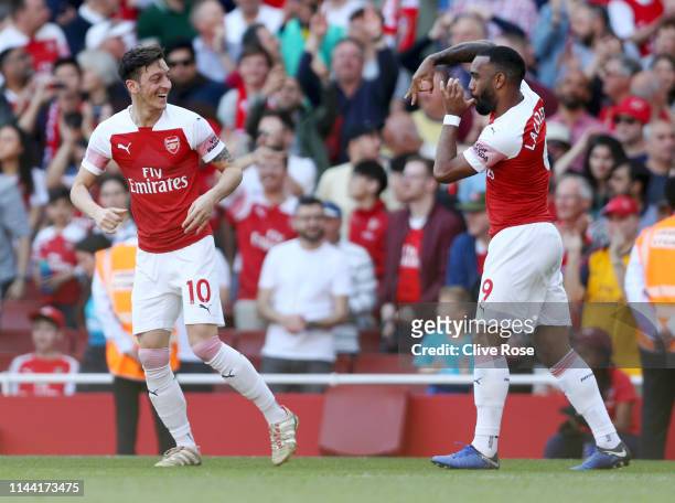 Mesut Ozil of Arsenal celebrates after scoring his team's first goal with Alexandre Lacazette during the Premier League match between Arsenal FC and...