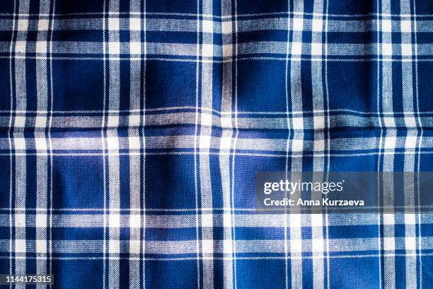 textile background with a checkered blue napkin, top view. natural textile background. fabric texture background. texture of natural linen fabric. - blue tartan stock pictures, royalty-free photos & images