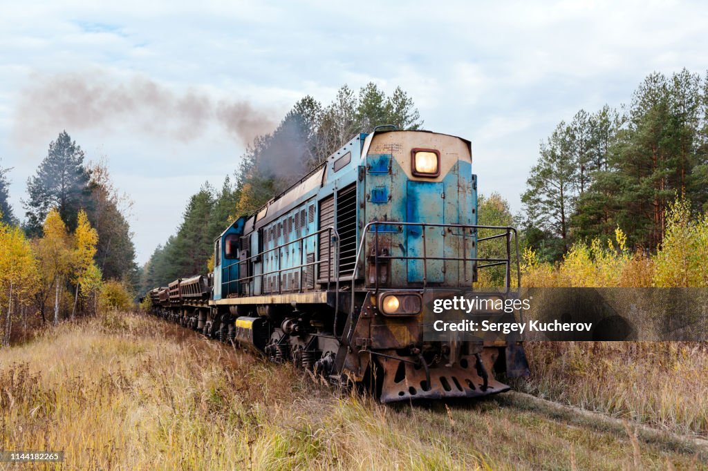TEM2U class diesel locomotive leads dump cars train loaded with sand from the quarry