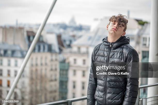 bored teenage boy paris cityscape background - pouting fotografías e imágenes de stock