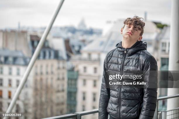 bored teenage boy paris cityscape background - jeunes garçons photos et images de collection