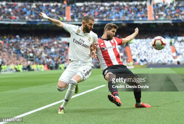 Karim Benzema of Real Madrid CF battles for the ball with Inigo Martinez of Athletic Club during the La Liga match between Real Madrid CF and...