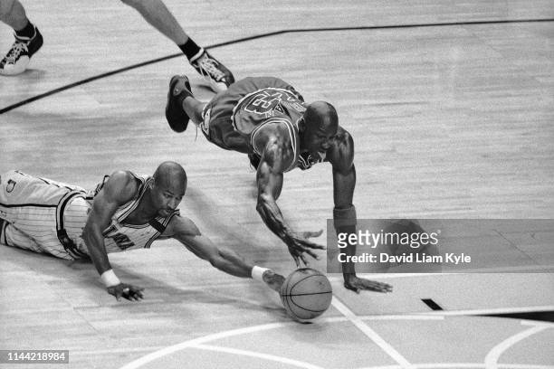 Michael Jordan of the Chicago Bulls reaches for a loose ball during Game Five of the 1999 NBA Eastern Conference Semifinals against Travis Best of...