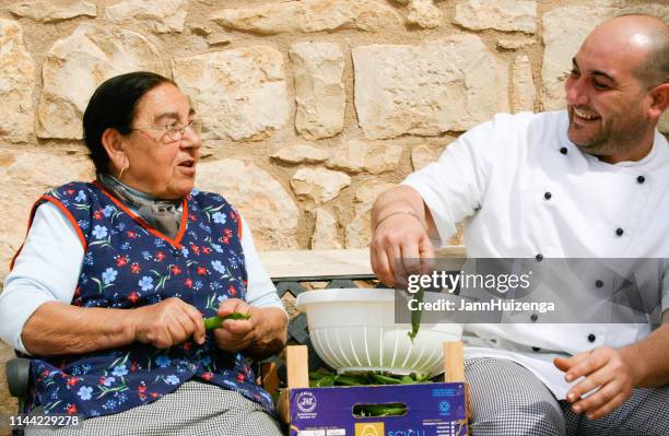 modica, sicily, italy: cooks shelling peas outside - modica sicily stock pictures, royalty-free photos & images