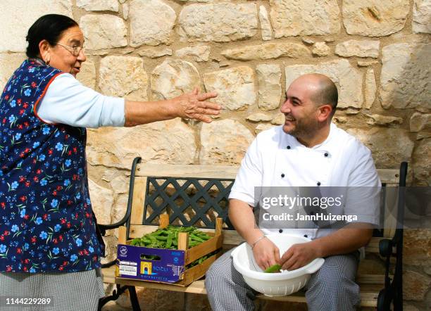 modica, sicily, italy: two cooks shelling peas outside - modica sicily stock pictures, royalty-free photos & images