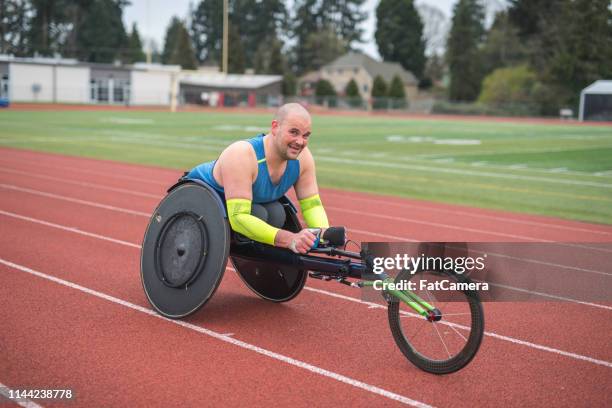 adaptive athlete training on his racing wheelchair on a stadium track - paraplegic race stock pictures, royalty-free photos & images