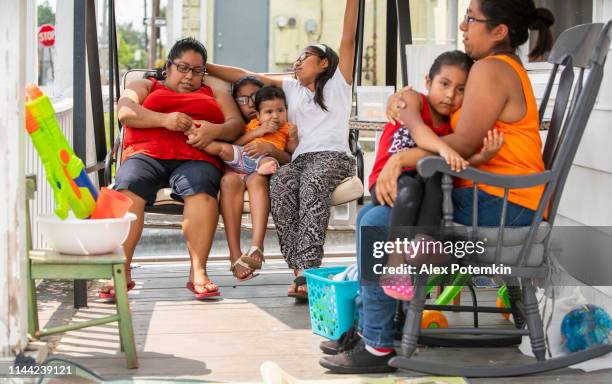 the big happy latino mexican-american family resting at the porch of his house - chubby girl stock pictures, royalty-free photos & images