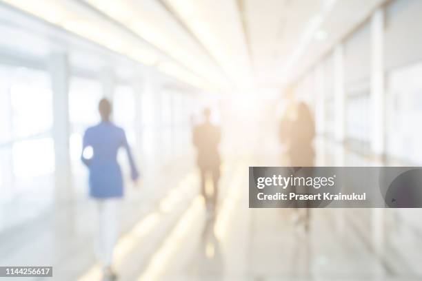 blurred background of businesspeople standing in the corridor of an business center - backgrounds people imagens e fotografias de stock