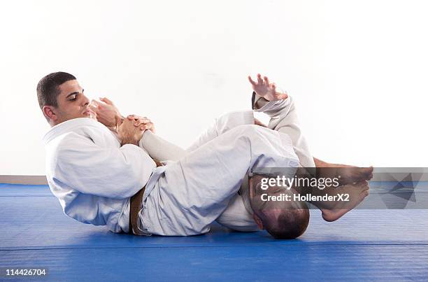 two men performing jiu jitsu martial arts holds. - sparring foto e immagini stock