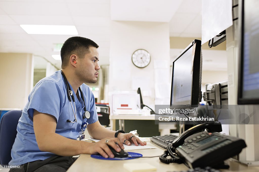 Doctor checks computer monitor.