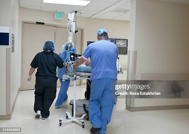patient being rushed through hospital corridor - hospital corridor stock pictures, royalty-free photos & images