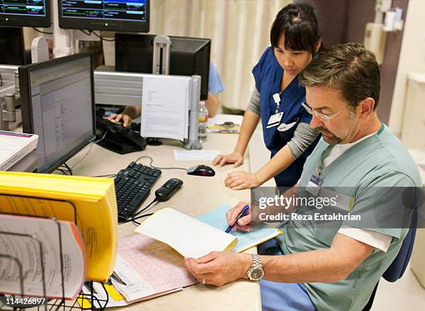 nurse discusses patient notes with doctor - doctor with male patient reading notes stock pictures, royalty-free photos & images