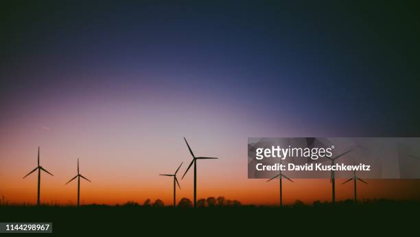 windräder im sonnenuntergang - paper windmill stock-fotos und bilder
