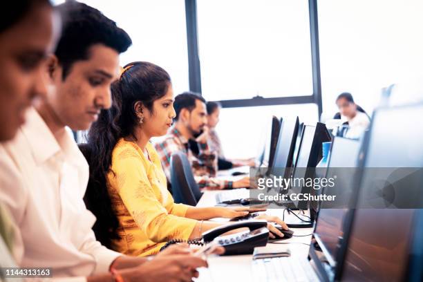 gruppo di dirigenti di call center che lavorano durante il turno - indiana foto e immagini stock