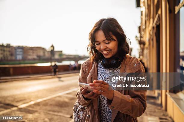 giovane donna adulta che esplora firenze in italia usando il suo cellulare al tramonto - filippino foto e immagini stock