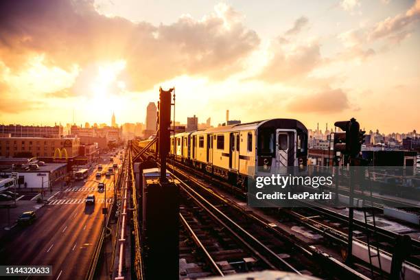 new york subway train approaching station platform in queens - queens imagens e fotografias de stock