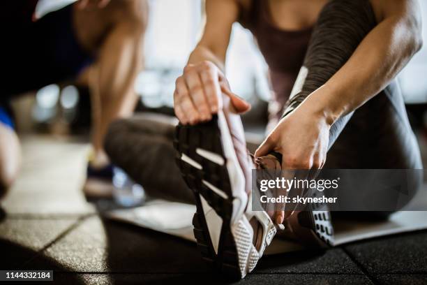 nahaufnahme der unerkennbaren frau, die schmerzen in ihrem knöchel im fitnessstudio. - ankle stock-fotos und bilder