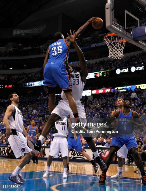 Kevin Durant of the Oklahoma City Thunder dunks the ball over Brendan Haywood of the Dallas Mavericks as Haywood is called for a foul in the first...