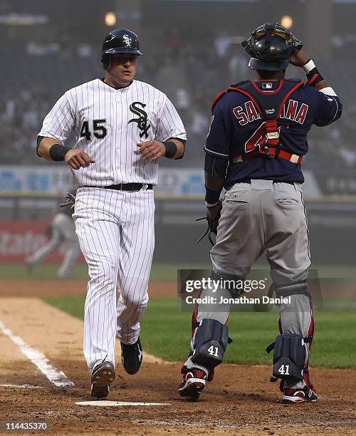 Dallas McPherson of the Chicago White Sox scores a run in the 2nd inning past Carlos Santana of the Cleveland Indians at U.S. Cellular Field on May...