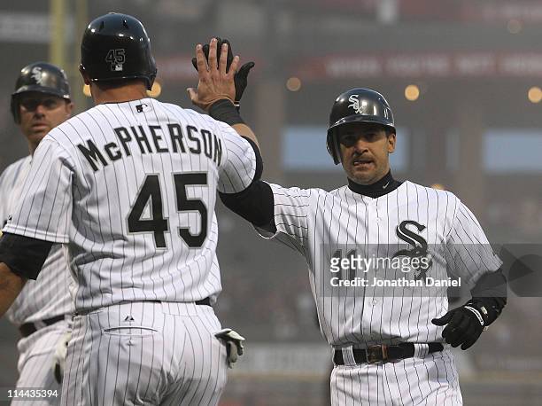 Dallas McPherson of the Chicago White Sox congratulates teammate Omar Vizquel after they scored runs in the 2nd inning past Carlos Santana of the...