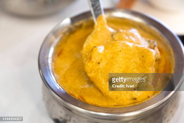 traditional indian cuisine, creamy fish curry - curry leaves stockfoto's en -beelden