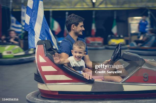 père et fils conduisant des voitures de dodgem - 2 cars family photos et images de collection