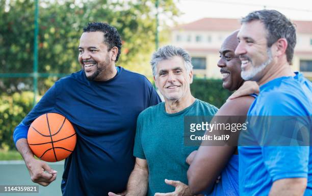 multi-ethnic group of middle aged men playing basketball - only men stock pictures, royalty-free photos & images