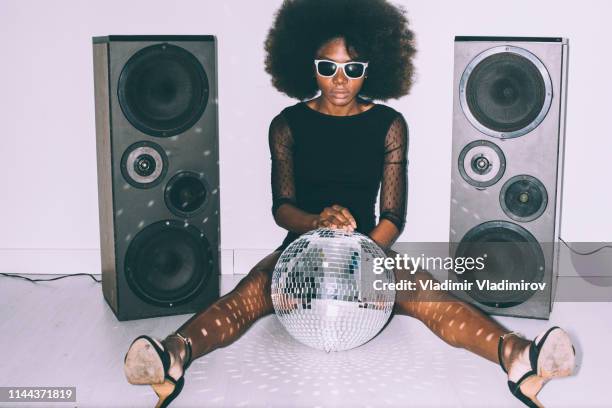 african woman in black dress and sunglasses holding disco ball - dance music stock pictures, royalty-free photos & images