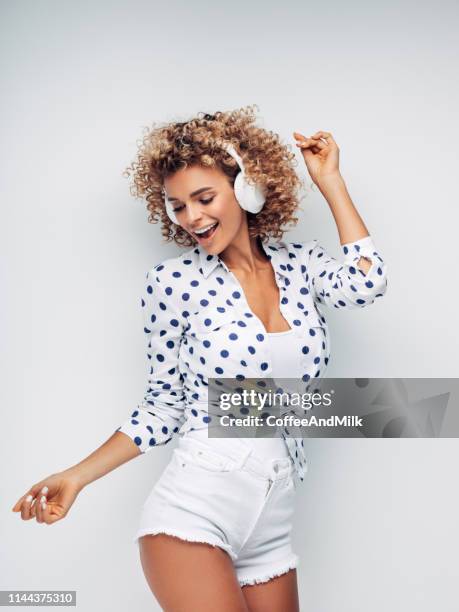 portrait of cheerful positive girl with headphones on her head listening music and dancing - female dj stock pictures, royalty-free photos & images