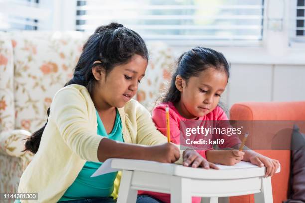 las hermanas hispanas escriben juntas - familia con dos hijos fotografías e imágenes de stock