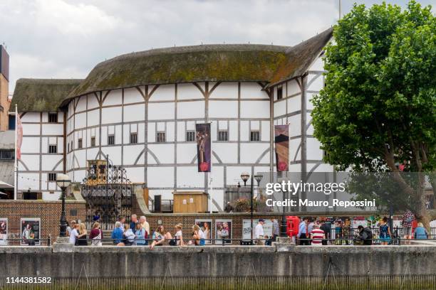 people walking on the thames river coast sideway next to the shakespeare theatre, know as "the globe", at the borough of southwark, london, england, uk. - globe theatre stock pictures, royalty-free photos & images